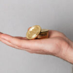 close-up-man-showing-stack-golden-bitcoins